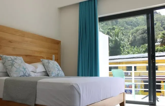 Bright and airy bedroom at Lyla Beach Villa, showcasing minimalist design and comfortable bedding for a relaxing beach vacation experience.