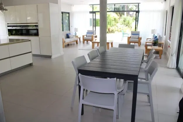 Modern open-plan living and dining area at Lyla Beach Villa with stylish furniture, large windows, and tropical views. Perfect for relaxing holidays and family gatherings by the beach.