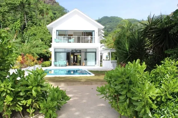 Luxurious white beachfront villa with modern design, private pool, and tropical gardens at Lyla Beach Villa. Perfect for a relaxing getaway in paradise.