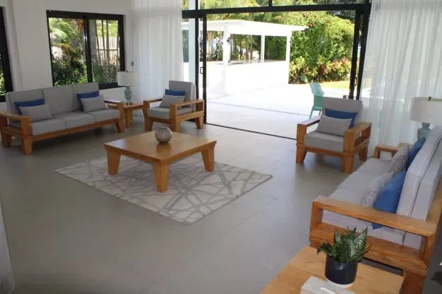 Modern living room at Lyla Beach Villa with stylish furniture, large glass doors opening to outdoor pool area, and contemporary decor perfect for relaxing beachside holidays.