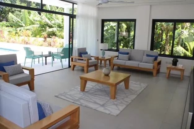 Modern living room at Lyla Beach Villa with stylish furniture, large windows, and tropical views, perfect for relaxing in a beachfront luxury villa.